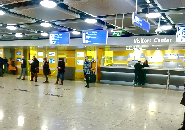 les chauffeurs avec pancartes alignés devant le visitors center dans le hall d'arrivée à l'aéroport de Genève