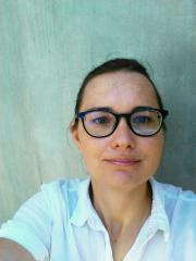 Photo de passeport de Alena Shahadat avec des lunettes devant un mur en béton gris